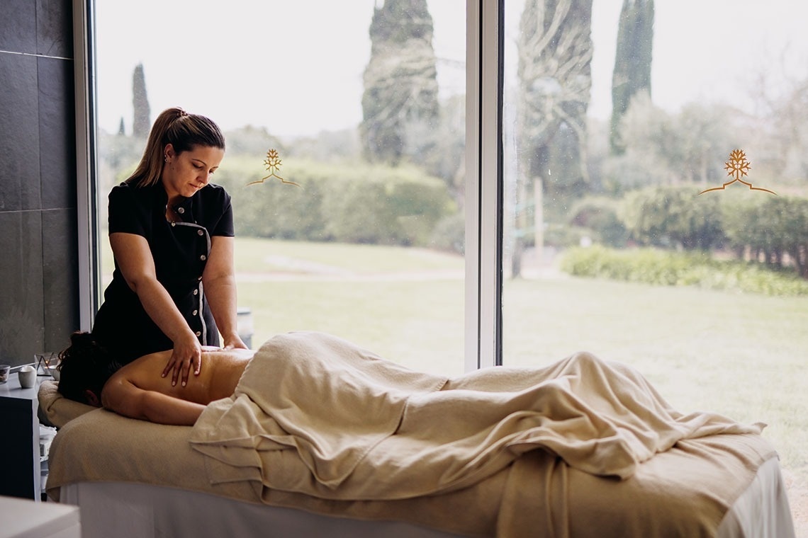 una mujer le da un masaje a un hombre en un spa