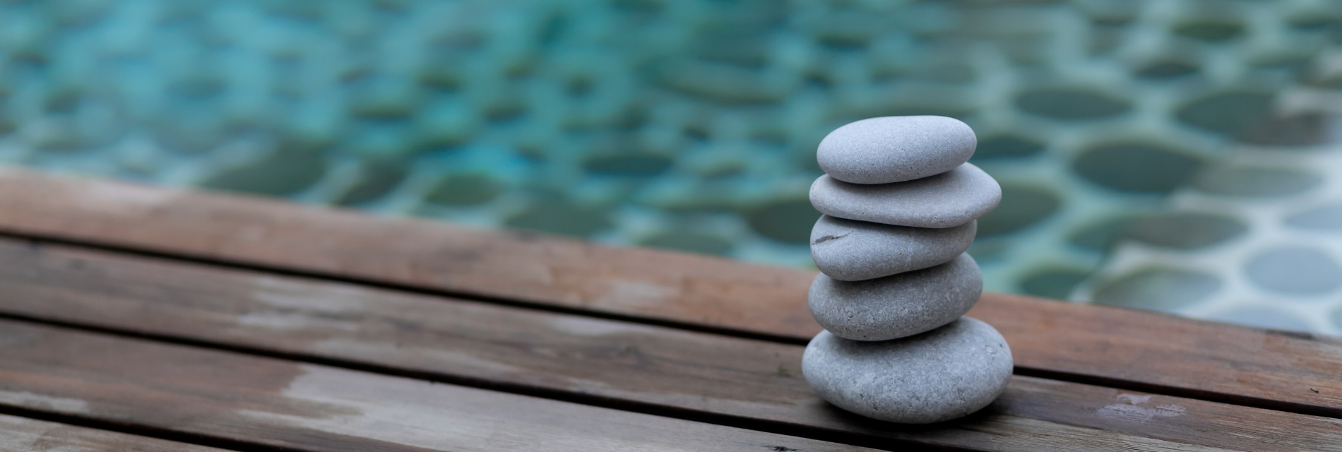 five rocks are stacked on top of each other on a wooden surface