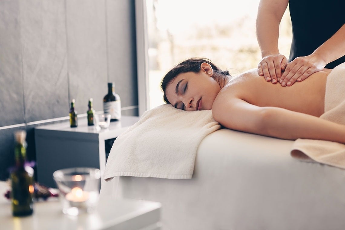 una mujer se sienta en una piscina rodeada de palmeras