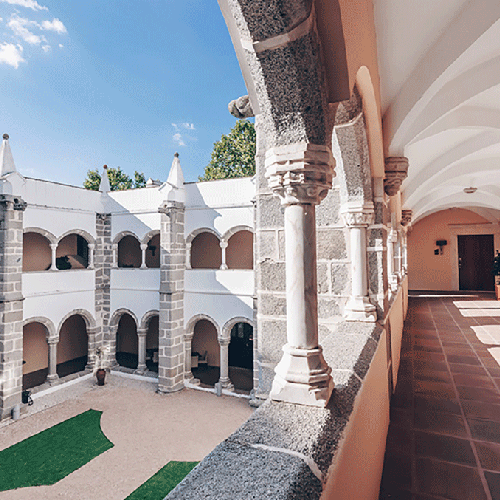un pasillo largo con columnas y arcos en un edificio