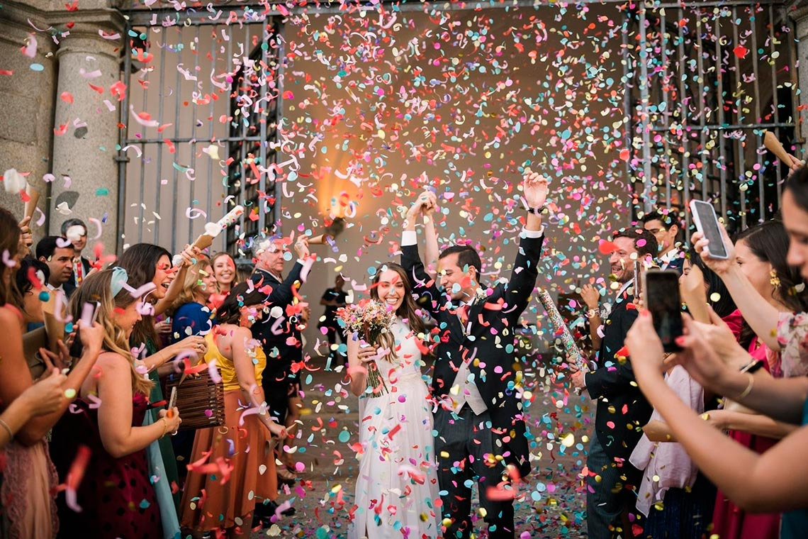 Bride and groom celebrate with confetti at a wedding at Convento do Espinheiro, Historic Hotel & Spa.