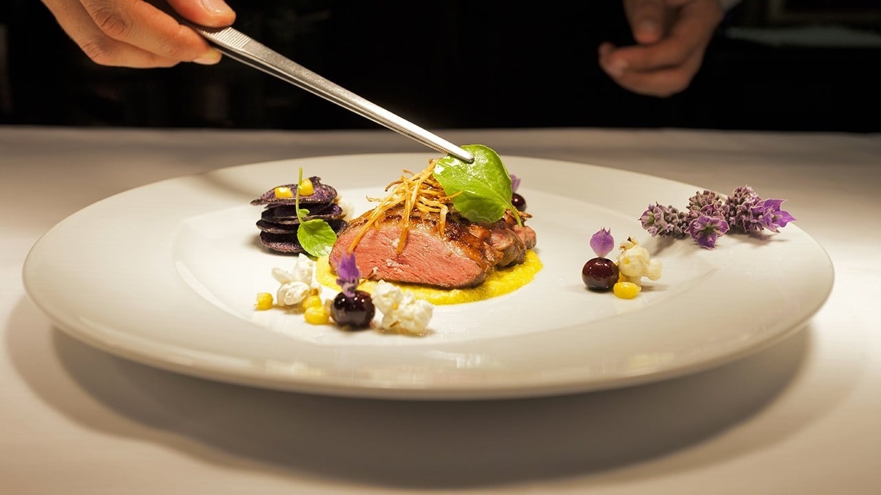 a white plate with a piece of meat on it