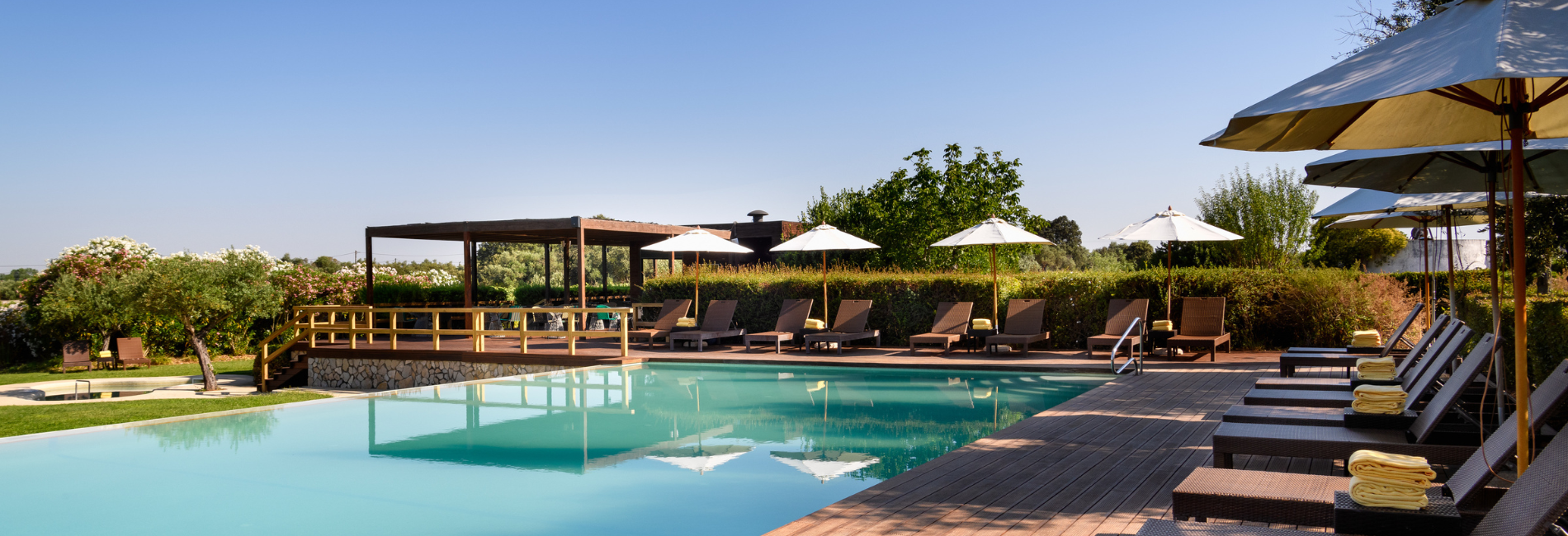 una piscina rodeada de sillas y sombrillas en un día soleado