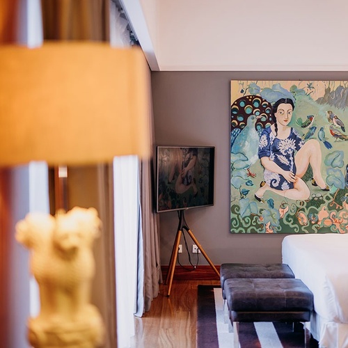 una habitación con una cama y una pintura en la pared