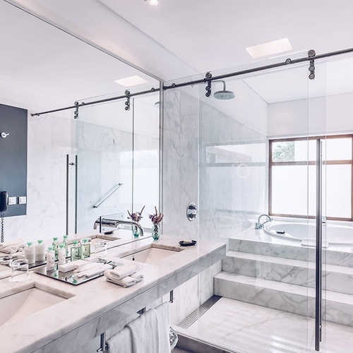 un baño con dos lavabos y una bañera