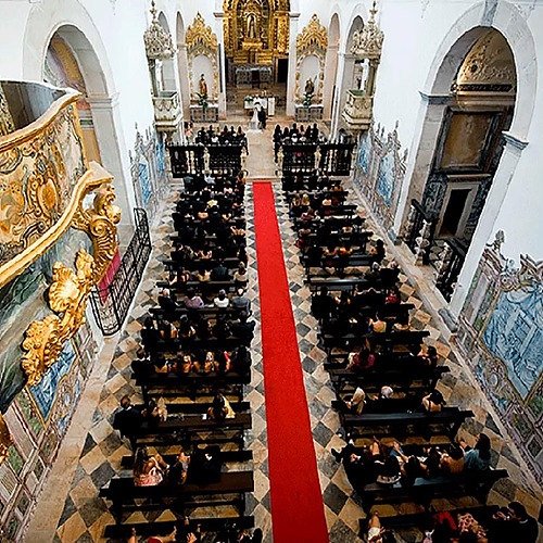 Boda en el Convento do Espinheiro: invitados sentados en bancos, alfombra roja.