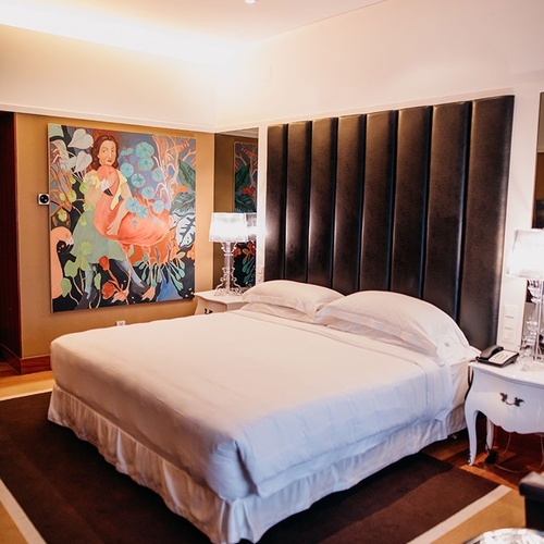 una habitación de hotel con una cama y una pintura en la pared
