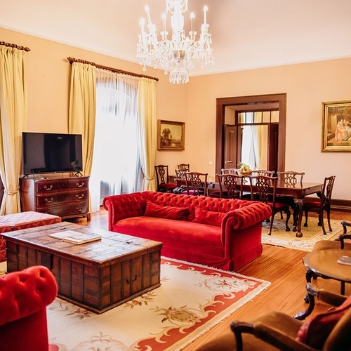 una sala de estar con sofás rojos y una mesa de comedor