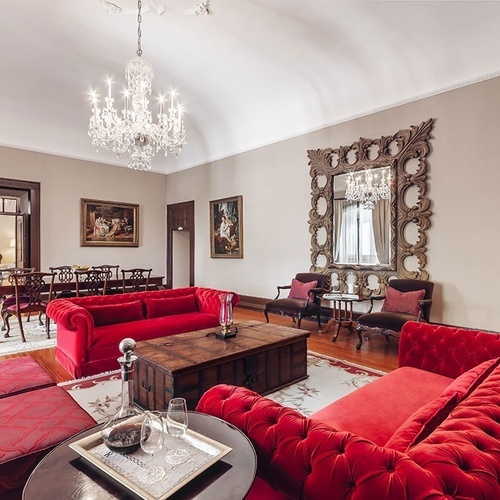 una sala de estar con sofás rojos y una mesa de madera