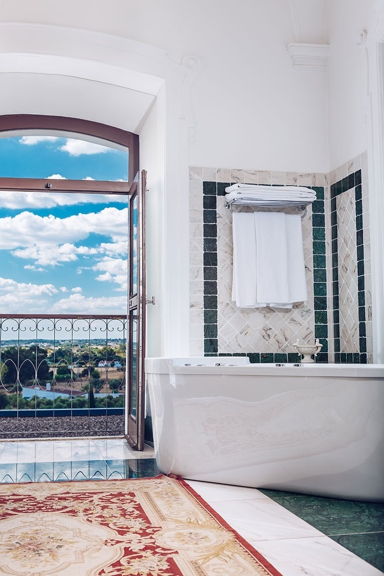 a bathroom with a large tub and a balcony