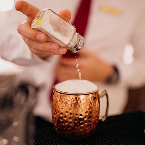 un hombre vierte sal en una taza de cobre