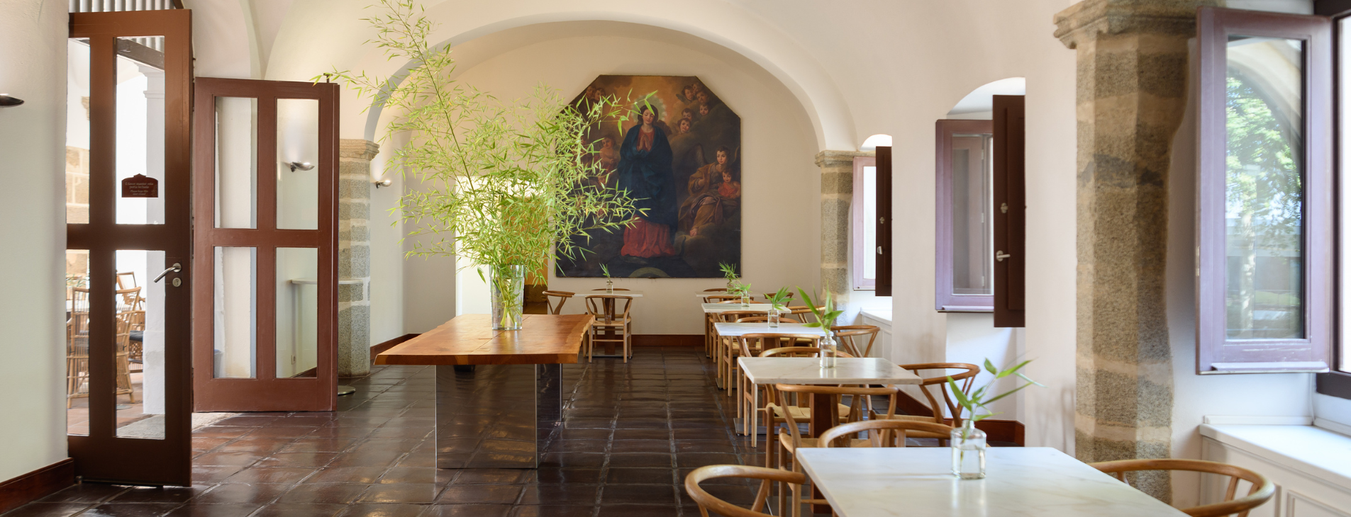 uma sala de jantar com mesas e cadeiras e uma pintura na parede