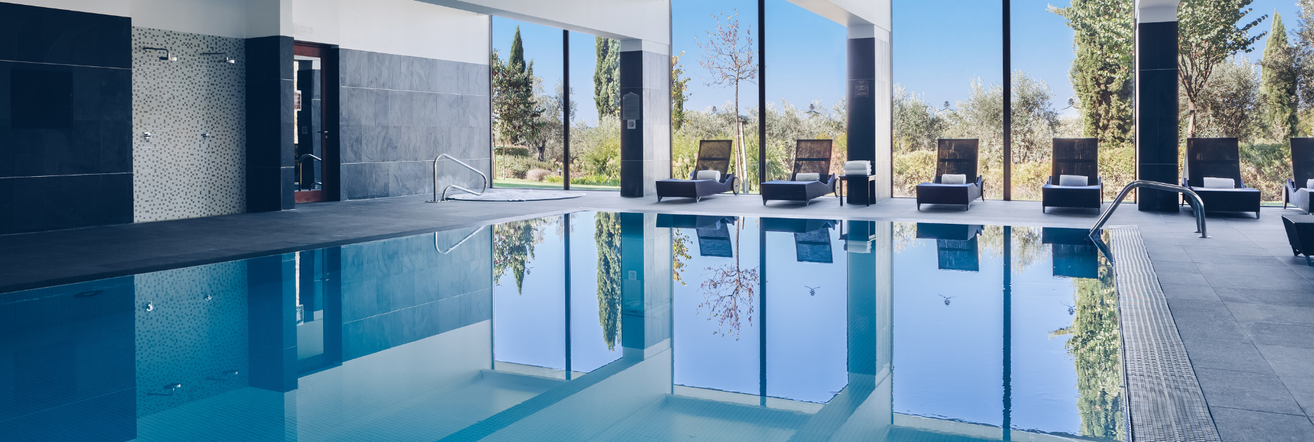 a large indoor swimming pool with chairs and a jacuzzi