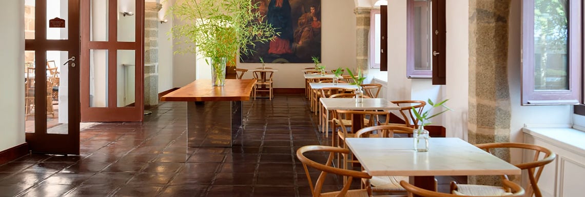 Elegant dining room at Convento do Espinheiro, Historic Hotel & Spa, featuring wood tables and chairs.