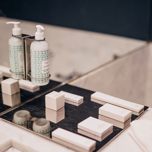 dos botellas de jabón están en un soporte en el baño