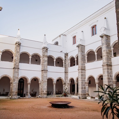 un edificio blanco con columnas de piedra y arcos