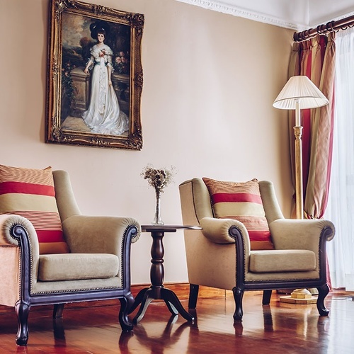 una sala de estar con dos sillas y un cuadro en la pared