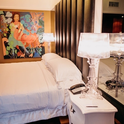 una habitación de hotel con una cama y dos lámparas