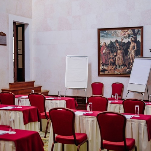 una sala de conferencias con mesas y sillas rojas
