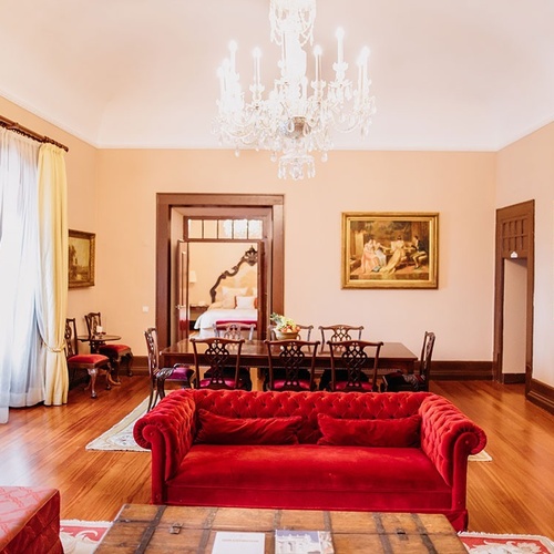 una sala de estar con un sofá rojo y una mesa de comedor