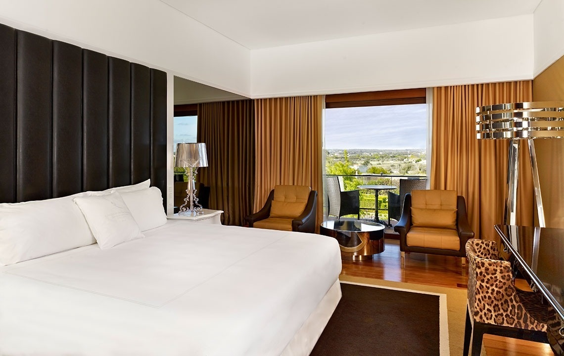 a hotel room with a large bed and chairs