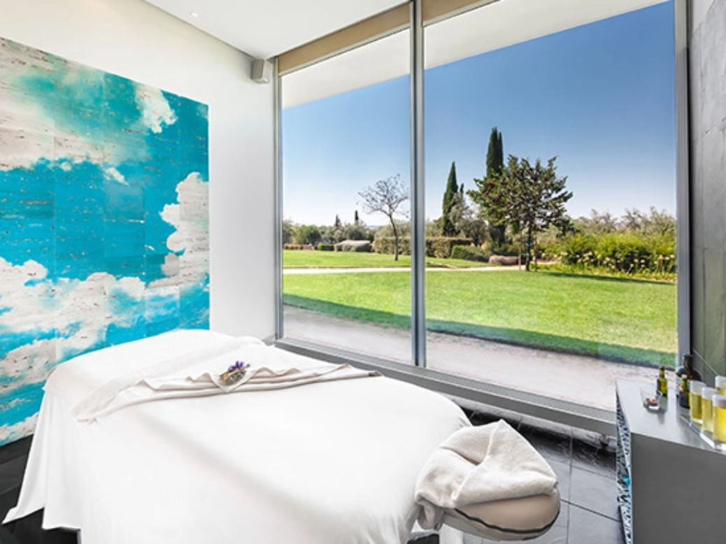 uma sala de massagem com uma cama e uma grande janela