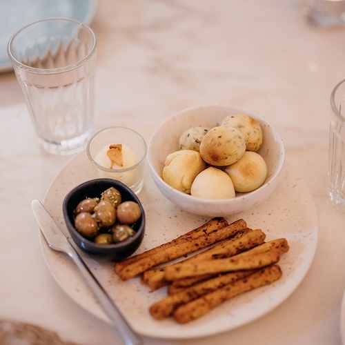 un plato blanco lleno de comida y un vaso de agua