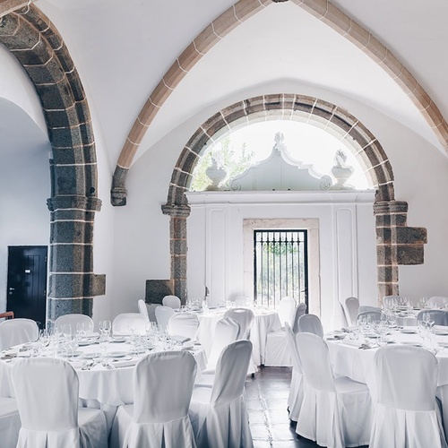 una habitación llena de mesas y sillas blancas