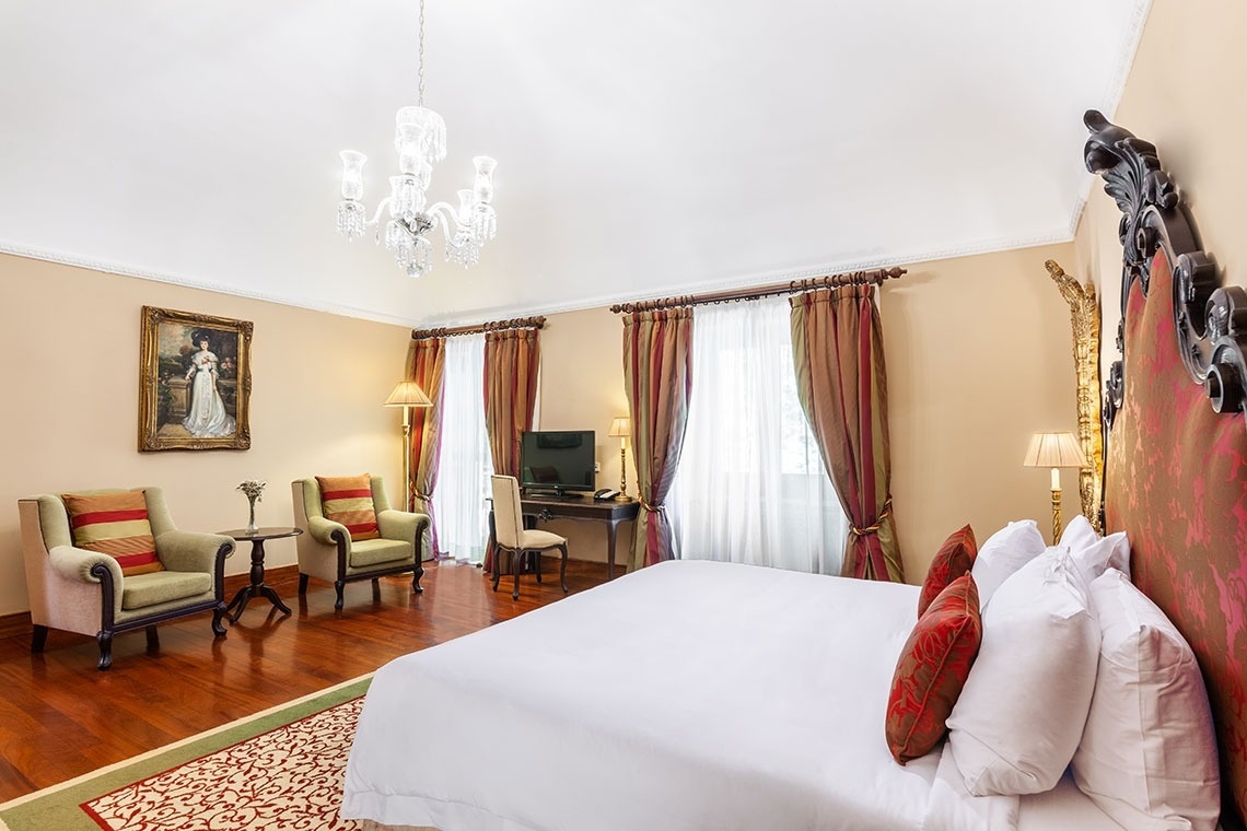 a bed with yellow pillows and white sheets in a hotel room