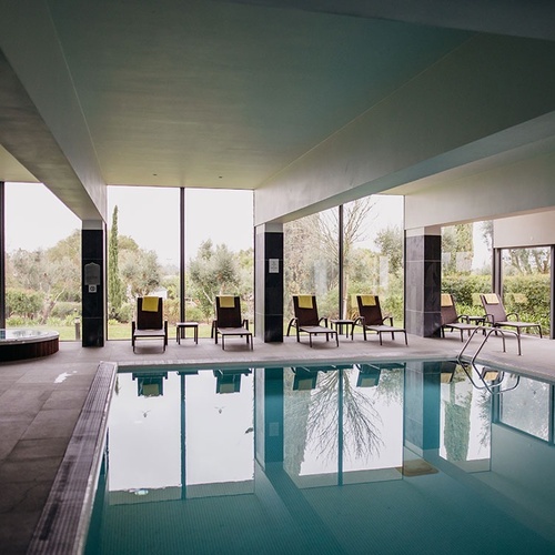 una piscina interior con sillas y un jacuzzi