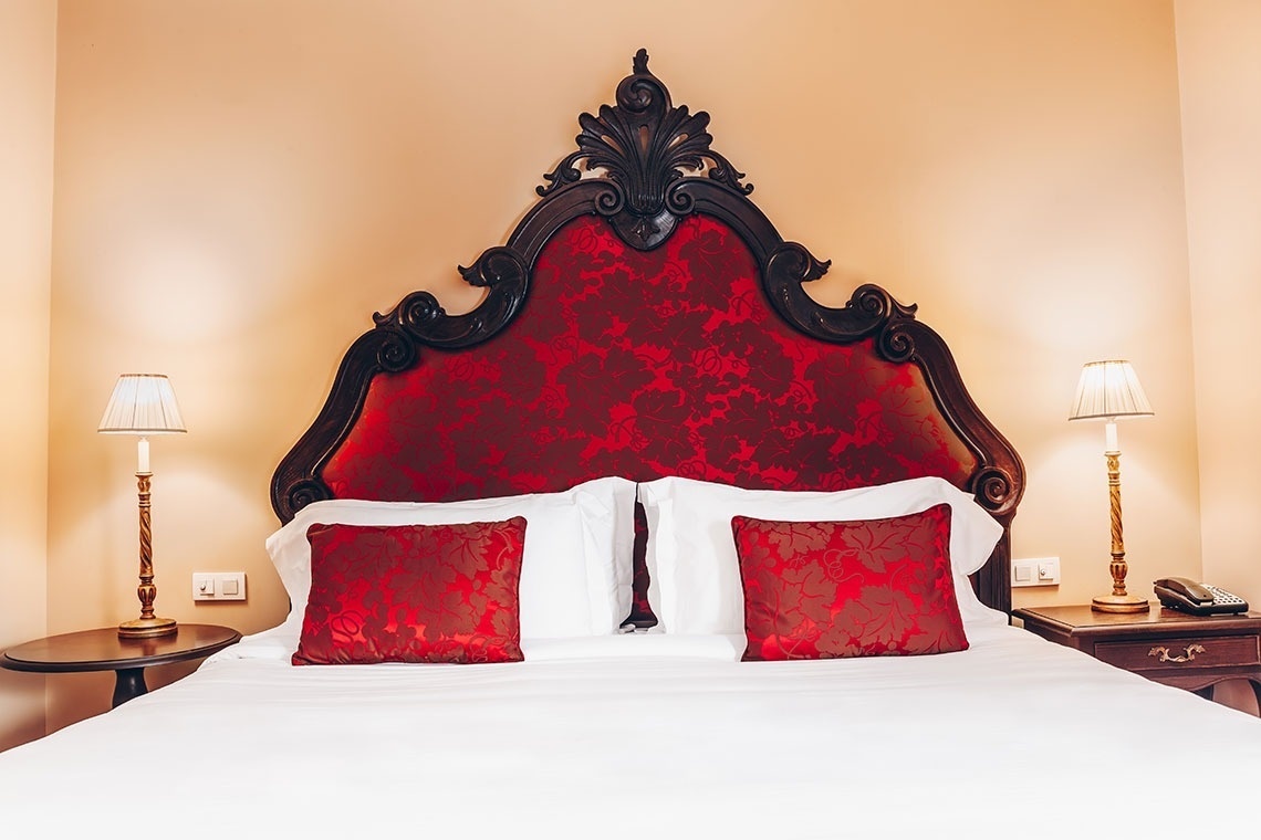 a bed with a red headboard and red pillows