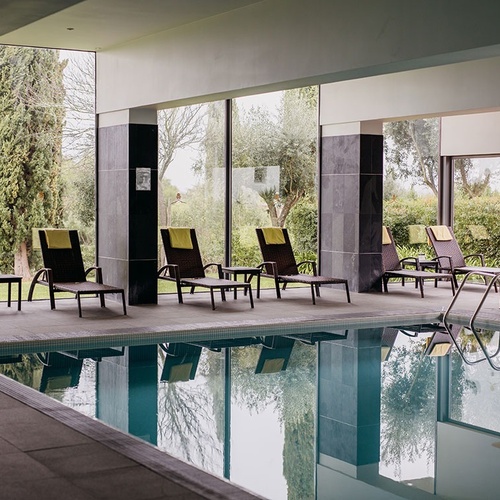 una piscina con sillas y mesas alrededor de ella