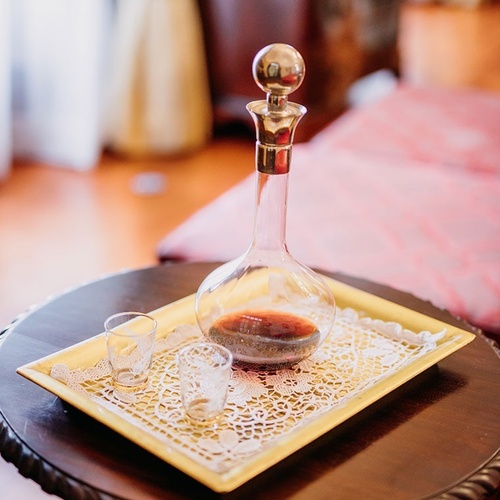 una botella de vino se sienta en una bandeja sobre una mesa