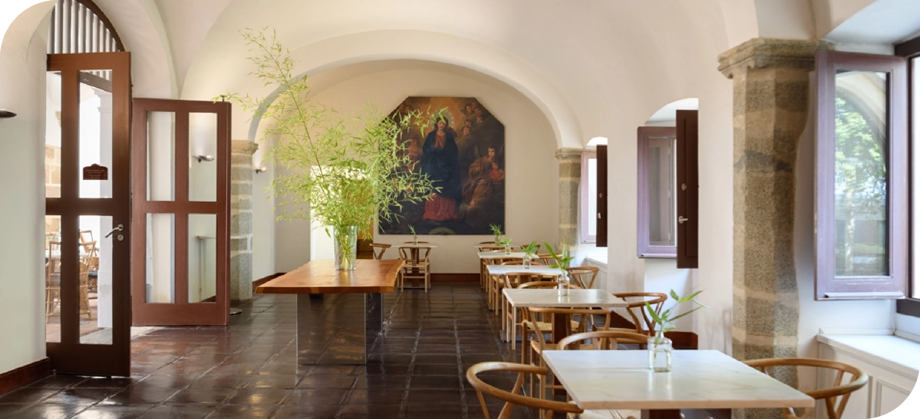 a room with tables and chairs and a painting on the wall