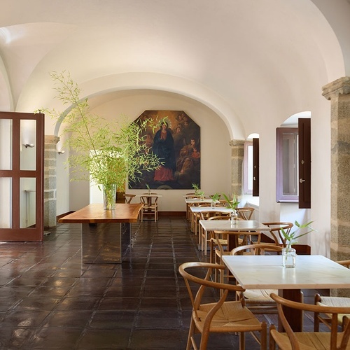 un comedor con mesas y sillas y una pintura en la pared