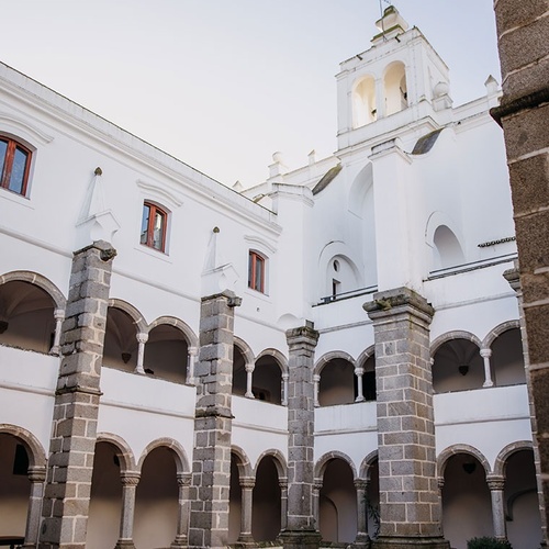 un edificio blanco con columnas de piedra y arcos