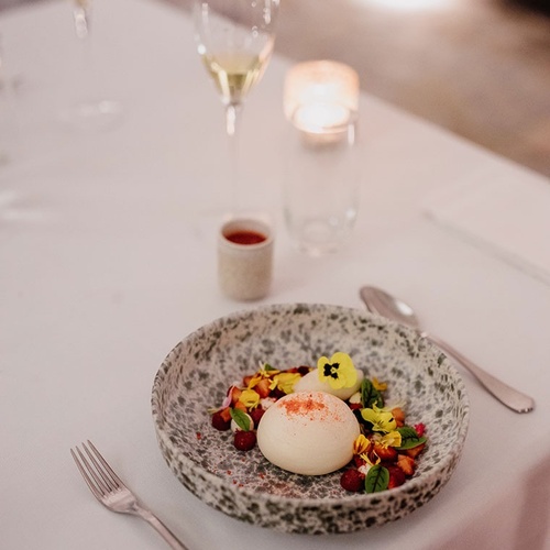 un plato de comida y un vaso de vino en una mesa