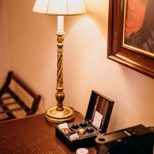 una caja de cápsulas de café está sobre una mesa junto a una lámpara