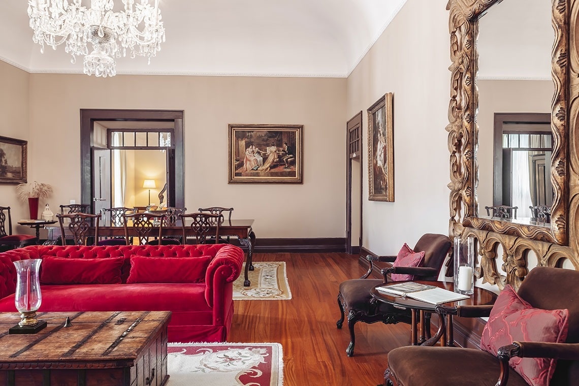a living room with a red couch and a painting on the wall