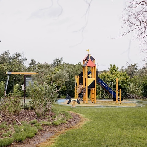un niño se sienta en un columpio en un parque