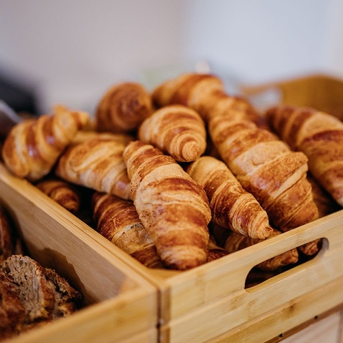 un montón de croissants en una caja de madera
