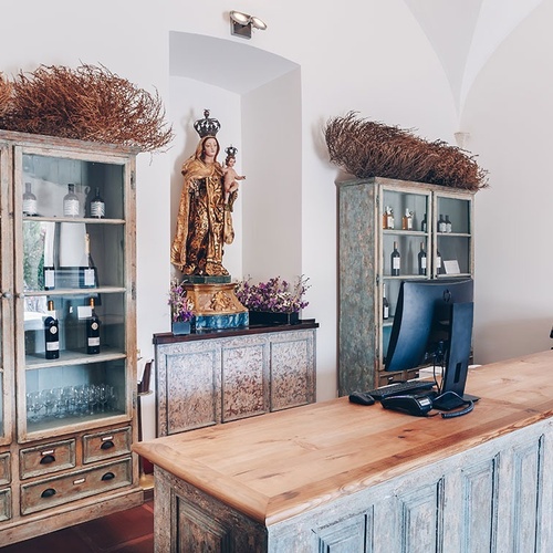 un mostrador de madera con botellas de vino y una estatua