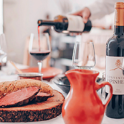 Servicio de vino tinto en Convento do Espinheiro, una experiencia culinaria.