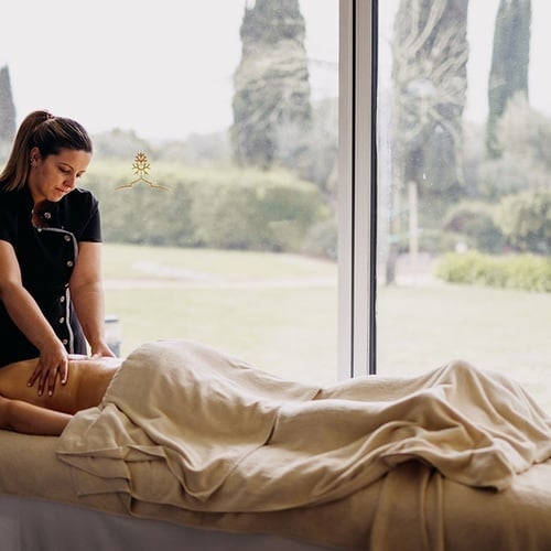 una mujer le da un masaje a un hombre en un spa