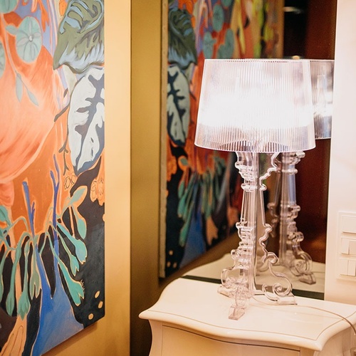 una mesa blanca con dos lámparas y un cuadro en la pared