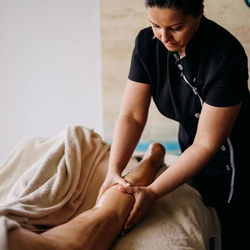 una mujer con una camisa negra está dando un masaje a un hombre