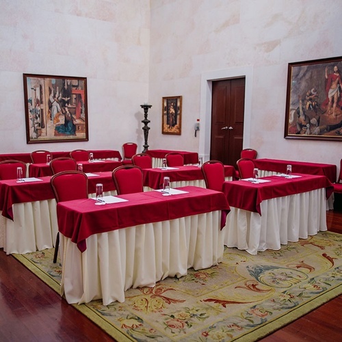 una sala de conferencias con mesas y sillas rojas y blancas