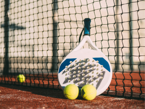 a tennis ball is being hit by a paddle on a tennis court .