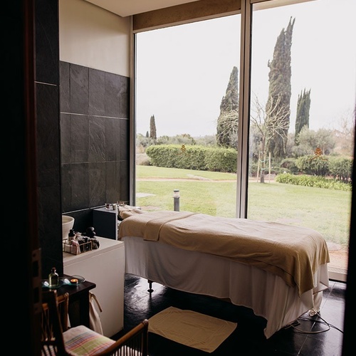 una habitación con dos camas de masaje y una gran ventana