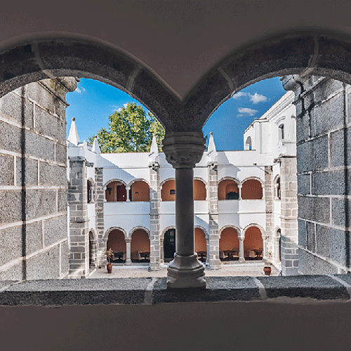 una vista de un patio a través de una ventana en forma de corazón